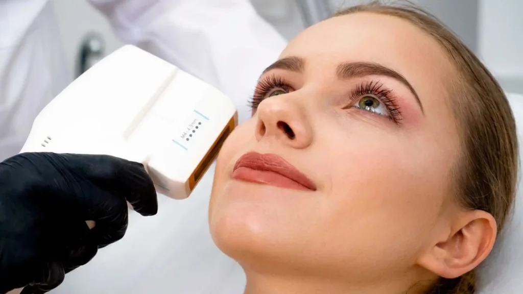 Refine this image to create a clean, high-end clinical aesthetic while keeping the original composition. Remove any graphic overlays, arrows, or dotted guide lines on the face to make the image look more natural and professional. Improve colour balance and skin tones while preserving realistic skin texture (avoid over-smoothing). Slightly reduce shine and enhance clarity for a premium dermatology photography look. Adjust lighting to be soft and neutral, with a bright, clean clinic feel. Keep the device and treatment area clear but subtle. No text, no overlays, no watermarks. Maintain a realistic, non-surgical cosmetic treatment style, high resolution.